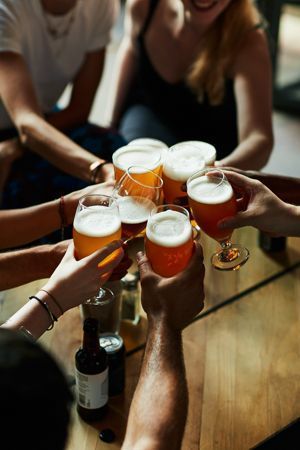 Hands with pint of beer cheersing